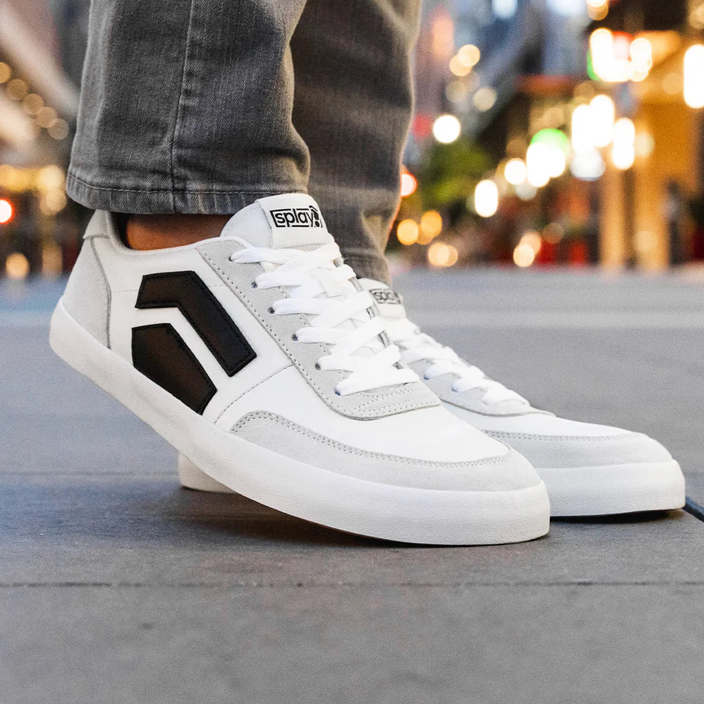 A person wearing gray jeans and a pair of Splay 101 sneakers.