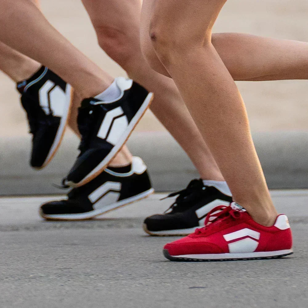 Runners wearing Splay Runner V1 natural running shoes with wide toe boxes and zero-drop soles during an outdoor run on a paved road.