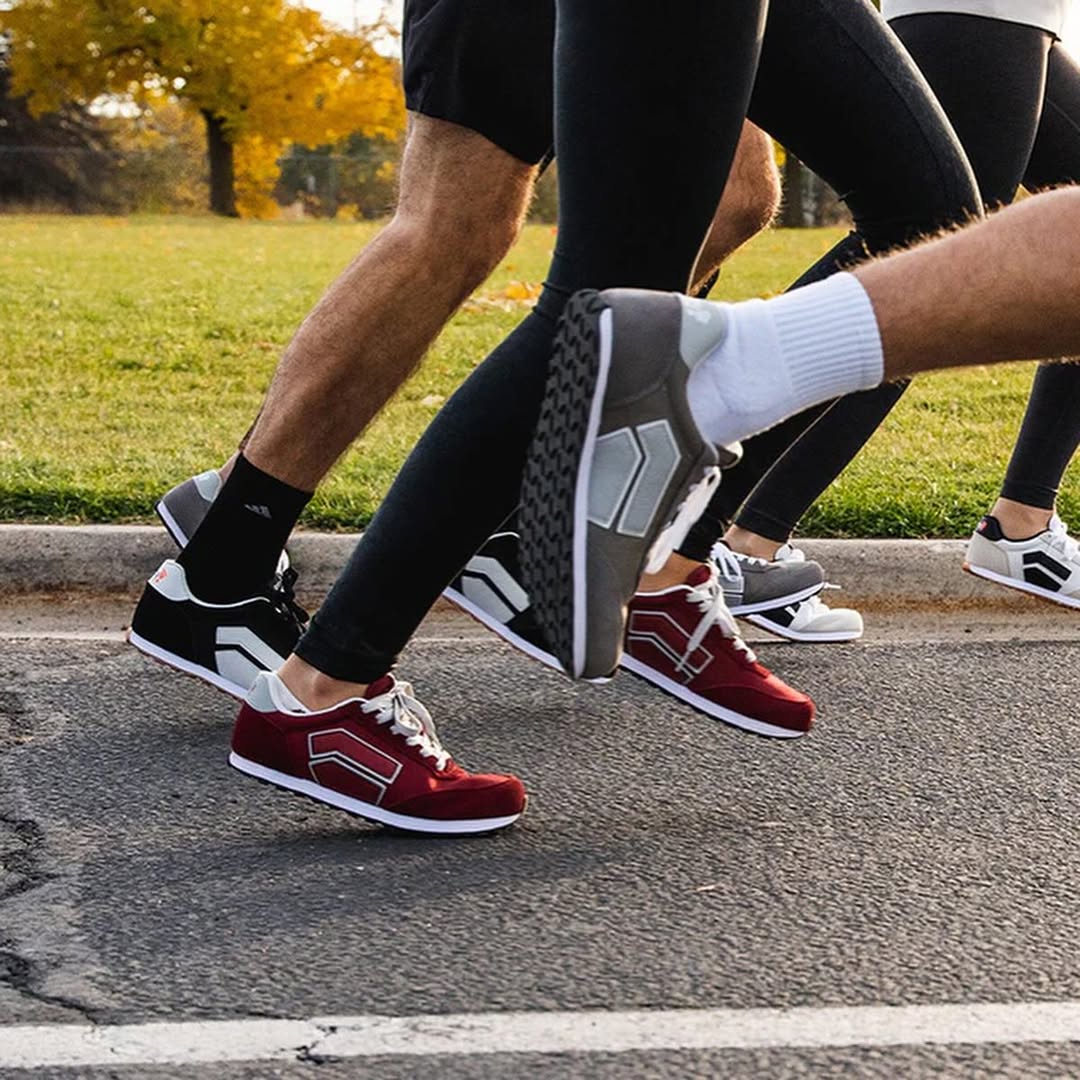 Group of runners wearing Splay RUNNER V1 barefoot shoes running mid-stride on a park road.