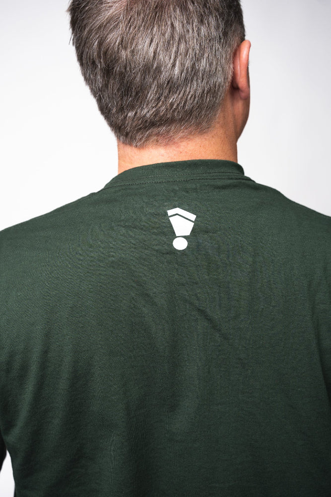 Person wearing a green shirt with a white logo on the back against a plain background