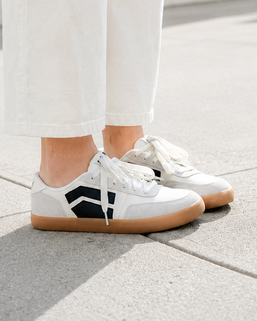 Splay 101 Blazer '26 barefoot shoes — low-top court sneaker with a side stripe and gum sole, lifestyle photo, the shoes shown in use outdoors