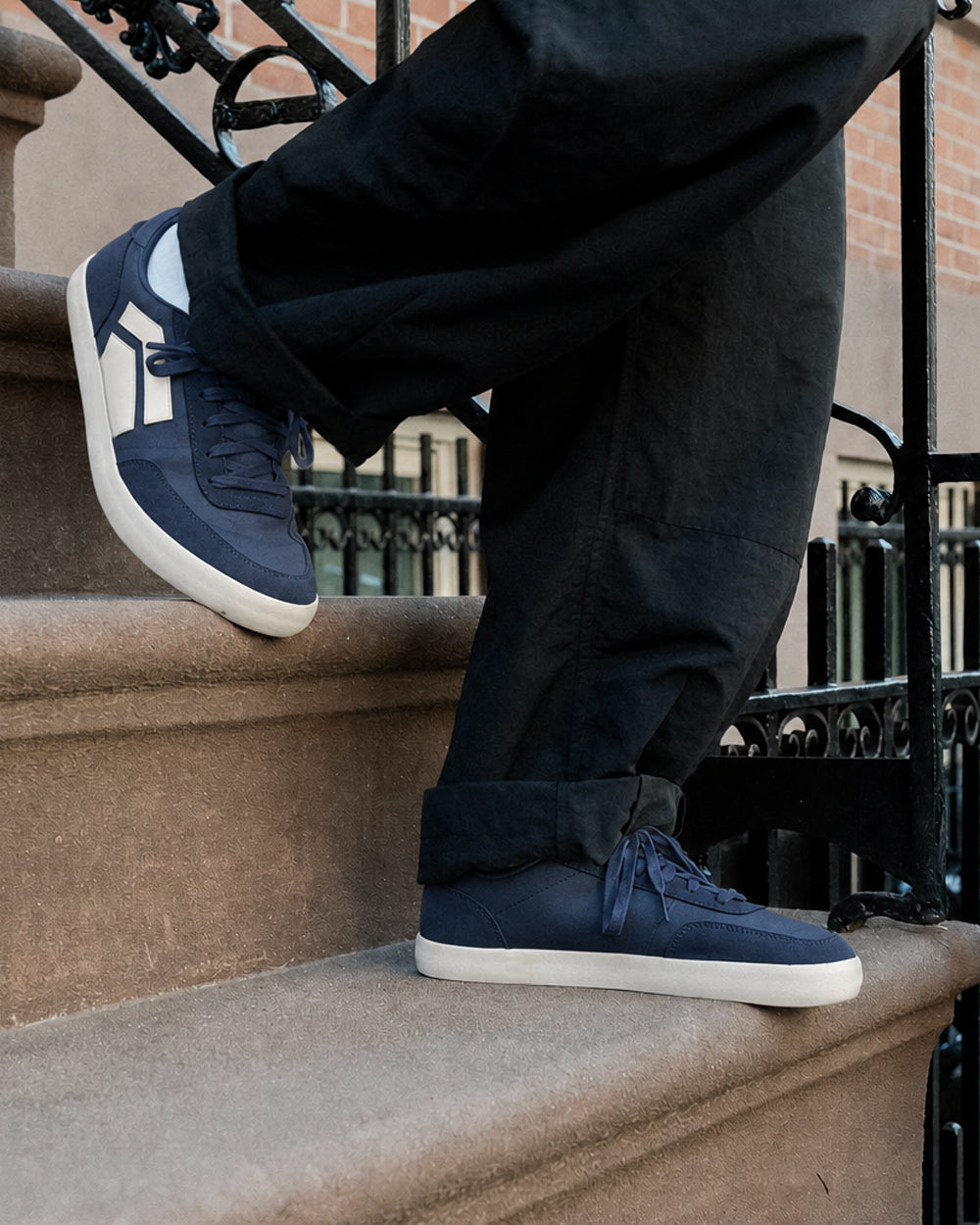 Splay 101 Oxford Blue '26 barefoot shoes — low-top court sneaker with a side stripe and gum sole, lifestyle photo, the shoes shown in use outdoors