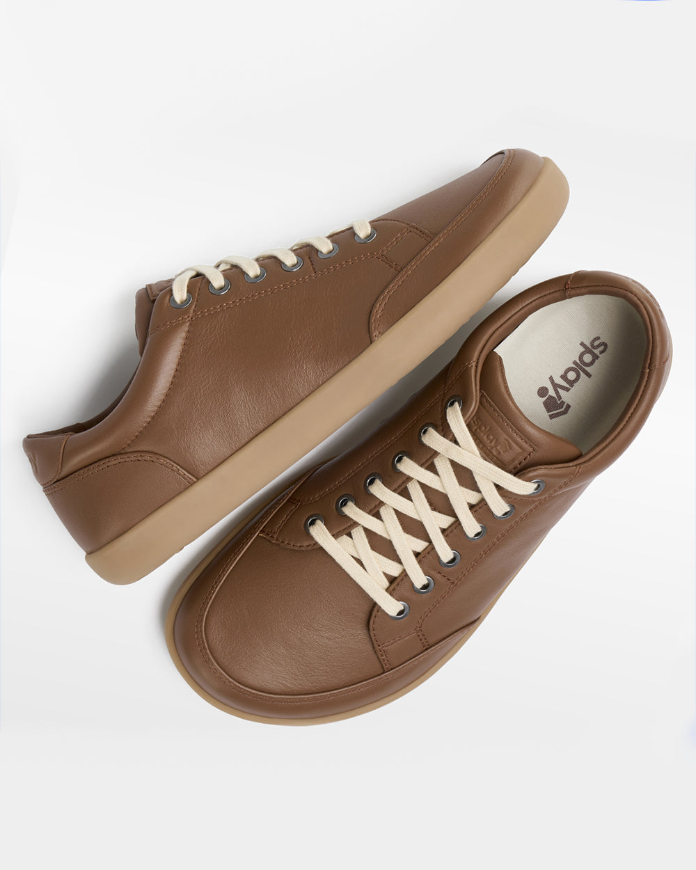 Splay Freestyle Leather Chestnut barefoot shoes — leather low-top lace-up sneaker, pair shot from above, one shoe tipped up to show the insole
