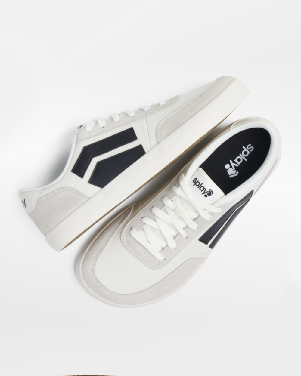 Splay 101 Graphite '26 barefoot shoes — low-top court sneaker with a side stripe and gum sole, pair shot from above, one shoe tipped up to show the insole